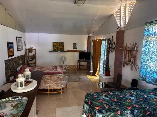 a bedroom with a bed and a living room at Kukuriaz Fare in Bora Bora