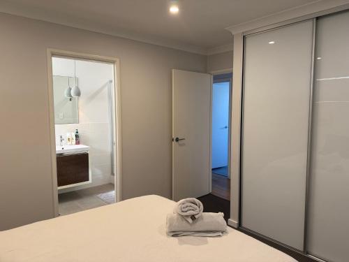 a bedroom with a bed with a towel on it at Coastal Retreat in Scarborough in Perth
