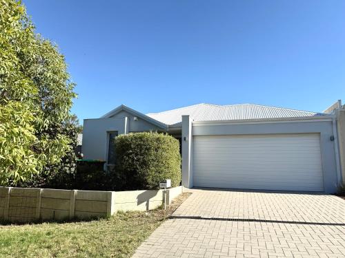 a house with a garage with a driveway at Coastal Retreat in Scarborough in Perth