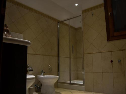a bathroom with a shower and a toilet and a sink at Villa Alaya in Manduria