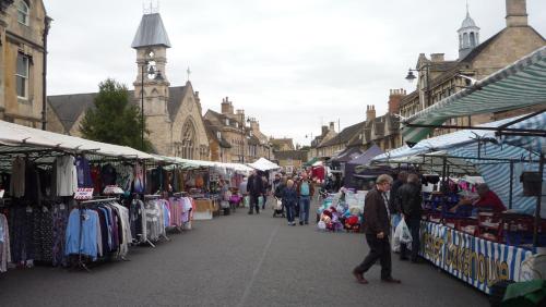 a group of people walking through an outdoor market at The Little Annexe in Stamford