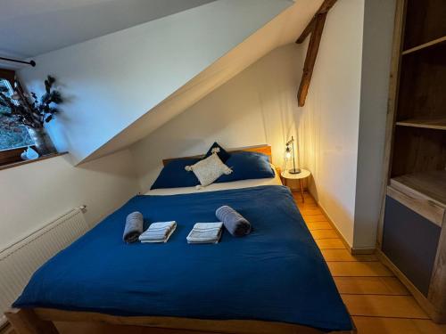 a bedroom with a blue bed with towels on it at Apartmán KSlife in Černý Dŭl