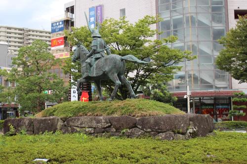 a statue of a man on a horse in a city at APA Hotel Hikoneminami in Hikone