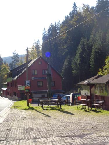 a group of picnic tables and an umbrella in front of a building at Gasthof Thomas Müntzer in Steinheid