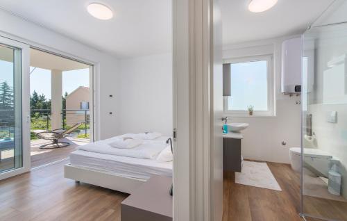 a white bedroom with a bed and a balcony at VILA PALISKA in Pula