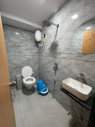 a bathroom with a white toilet and a sink at Hotel Pine Lake in Ahmedabad