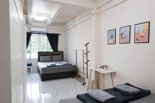 a small bedroom with a bed and a table at ดอนเมือง 302 Near DMK Airport BTS Wat PhraSi in Bang Khen