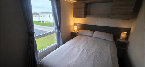 a bedroom with a bed and a large window at S & S Retreat in Heysham