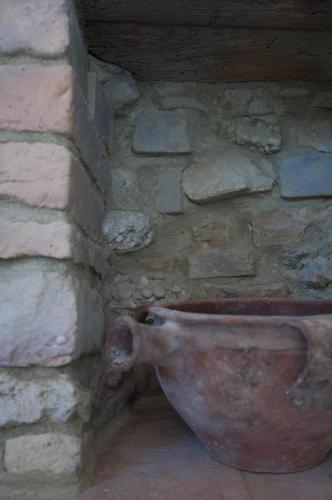 a clay pot in the corner of a stone wall at La Casa Del Palombaro in Ortona