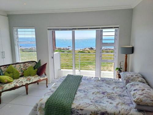 a bedroom with a bed and a view of the ocean at West Coast Rock in St. Helena Bay