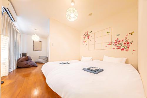 a bedroom with a large white bed in a room at Koei in Yokohama