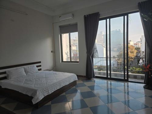 a bedroom with a bed and a large window at TH Homestay in Danang