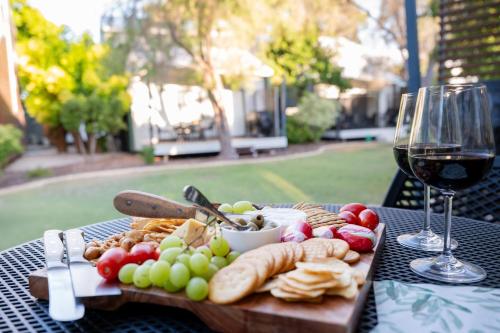 a table with a plate of food and a glass of wine at Serenity & Sea at Preston Beach WA in Preston Beach