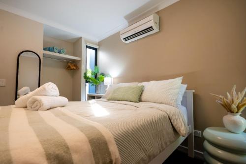 a bedroom with a bed with a blanket and a fan at Serenity & Sea at Preston Beach WA in Preston Beach
