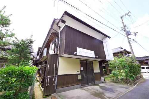 a brown and white building on the side of a street at 旧GATE80香住 無人宿 完全セルフ 予約メッセージ欄確認要す スマートロック 暗証番号チェックイン 素泊まり専門 アメニティ持参で格安滞在 セコム24h監視 駐車場10台 in Kami