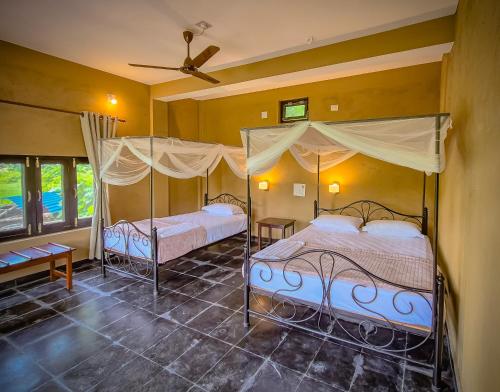 two beds in a bedroom with a ceiling at Babai Outback Adventures PVT LTD in Bardiyā