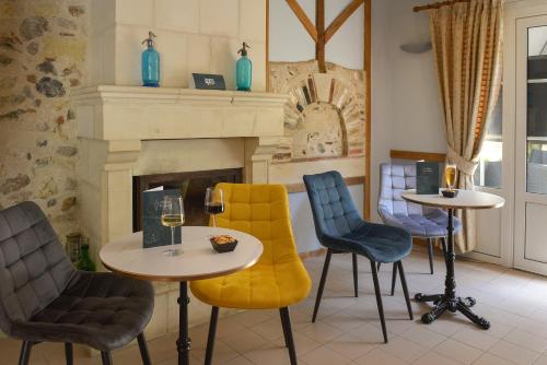 a room with chairs and tables and a fireplace at Auberge Le Colombien - Hôtel et Restaurant in Villandry