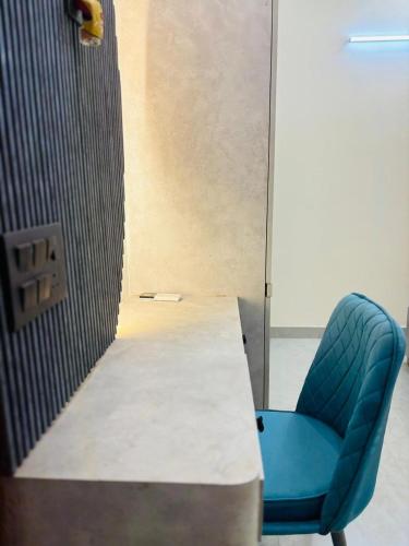 a blue chair sitting next to a table in a room at Pg walaah suites in Noida