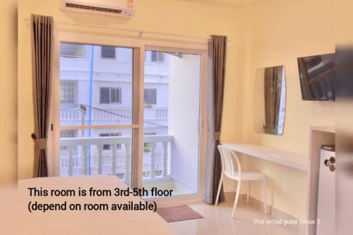 a room with a door open to a balcony at Thai Orchid Guest House in Jomtien Beach