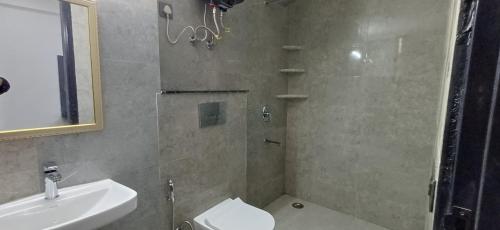 a bathroom with a shower and a toilet and a sink at Ganga Aura in Gurgaon