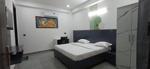 a bedroom with a bed and a painting on the wall at Ganga Aura in Gurgaon