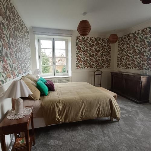 a bedroom with a large bed and a window at Les chambres du Lohan in Daoulas