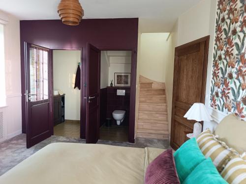 a bedroom with a bed and a bathroom at Les chambres du Lohan in Daoulas