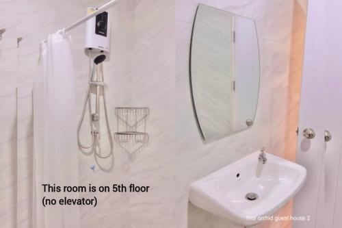 a bathroom with a sink and a mirror at Thai Orchid Guest House in Jomtien Beach