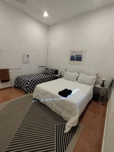 a bedroom with a large white bed and a rug at Homestay Stay Kartoon Pantai Merdeka in Kampong Pengkalan Batu Lintang