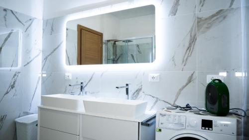 a bathroom with a sink and a washing machine at Appartamento Nerio in Muggia