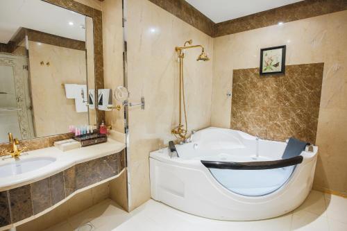 a bathroom with a bath tub and a sink at Rest Night Serviced Apartments- AlHamra in Riyadh