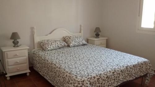 sypialnia z białym łóżkiem i 2 szafkami nocnymi w obiekcie Casita Andaluza w mieście San Luis de Sabinillas