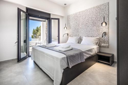 a bedroom with a large bed and a large window at Villa Daniela & Apartments in Koutsounari