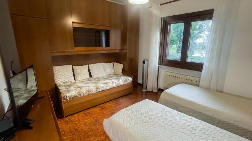 a small room with two beds and a window at Appartamento Nerio in Muggia