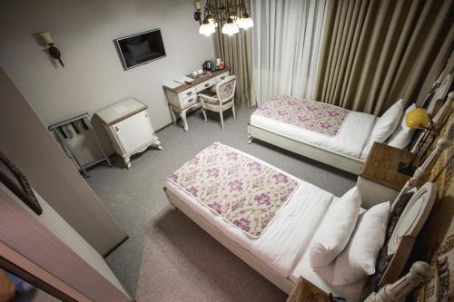 a bedroom with two beds and a desk and a desk at Boutique Hotel Baku in Baku