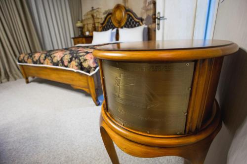 a room with a bed and a table with a clock at Boutique Hotel Baku in Baku