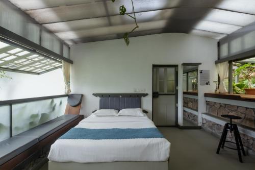 a bedroom with a bed and a large window at Malhar - Your Home Beneath The Clouds in Sultan Bathery