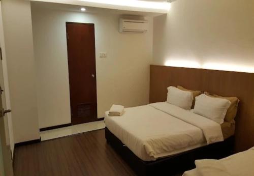 a bedroom with a large bed with a wooden headboard at Point Stay BDC Airport in Kuching