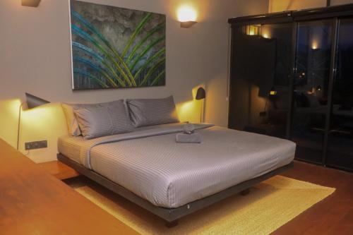 a bed in a room with a painting on the wall at Elevate Ella Resort & Spa in Ella