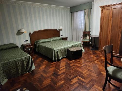 a bedroom with two beds and a wooden floor at Pretoria Collection in Potenza
