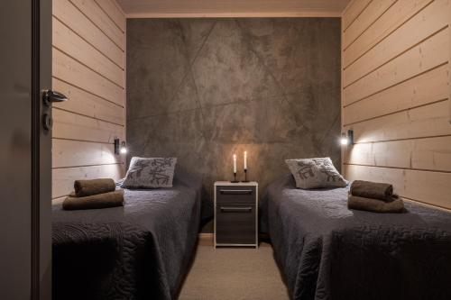 two beds in a room with two candles on them at Louhi A in Äkäslompolo