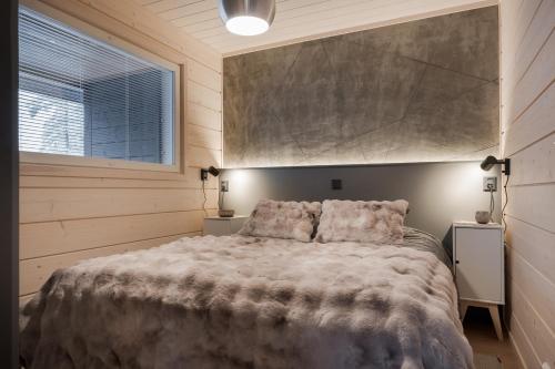 a bedroom with a large bed and a window at Louhi A in Äkäslompolo