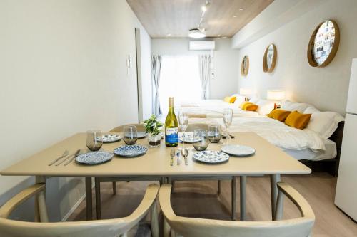 a dining room with a table and chairs and a bed at Zee Haven nagasakiekimae - ZEE HAVEN長崎駅前 in Nagasaki