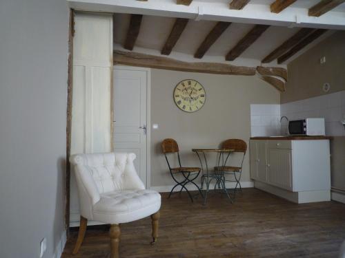 a living room with a white chair and a table at Villa Roma B&B in Amboise