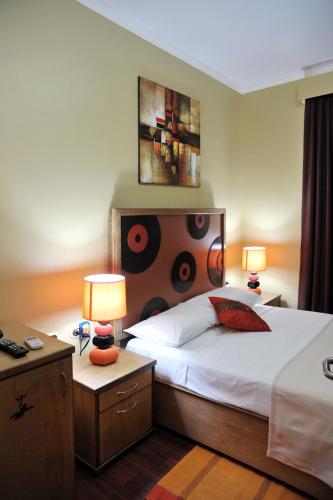 a bedroom with a large bed with two lamps on it at Culture Crossroads Inn in Port-of-Spain