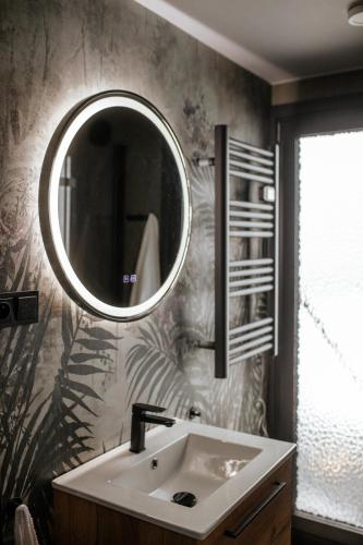 a bathroom with a sink and a mirror on the wall at Domek Jak z Obrazka in Sierpnica