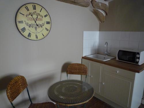 a room with a table and a clock on the wall at Villa Roma B&B in Amboise