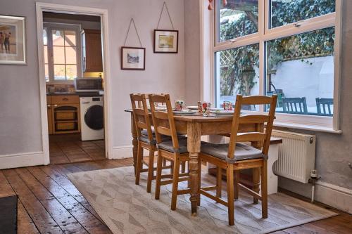 a kitchen with a wooden table and two chairs at Large family home, sea view, hot tub, beach 5 min walk, dog friendly in Gorleston-on-Sea