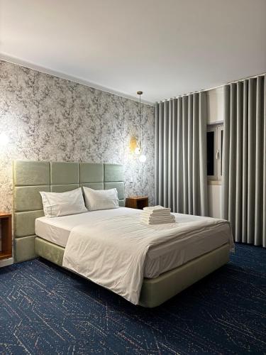 a bedroom with a large bed with a green headboard at White Guest in Fátima