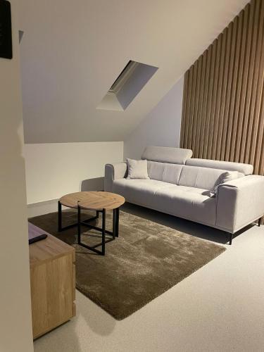 a living room with a white couch and a table at De Kempische Hoef in Westerlo